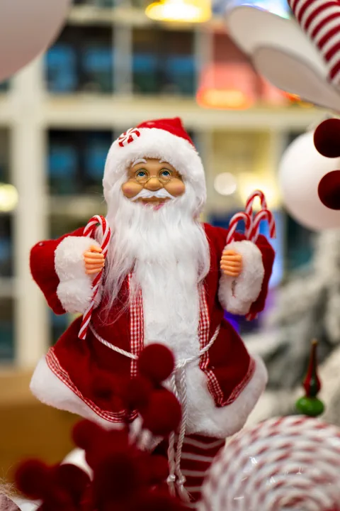 Un Babbo Natale in rosso e bianco con un bastoncino di zucchero in mano